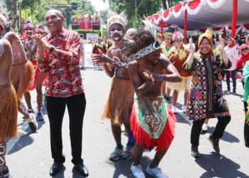 Wali Kota Jayapura DR. Benhur Tomi Mano, MM dan Wali Kota Surabaya Tri Rismaharini saat ikut memperagakan tarian Papua pada ajang Surabaya Vaganza 2018
