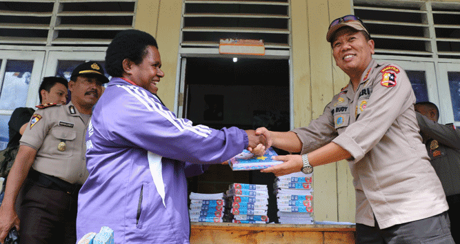 Kepala SMP YPPGI, Ibu Mendien Kogoya saat menerima bantuan buku tulis dan pakaian dari Satgas Binmas Noken Polri