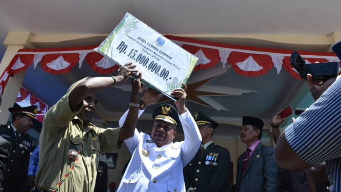 Bupati Mamberamo Raya saat menyerahkan secara simbolis dana pembinaan kepada tiga kampung yang terbaik mengelola dana desa