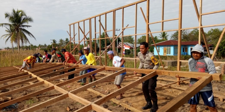 Bhabinkamtibmas Bantu Warga Kampung Telaga Sari Bangun Gedung BUMK