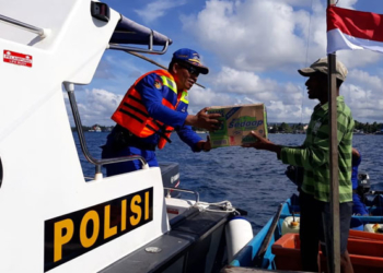 Kasat polair Iptu Nurdin Rahmati. SH saat memberikan Bendera Merah putih dan Bantuan sembako kepada Nelayan