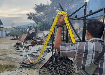 Anggota Polisi ketika melakukan police line di TKP.(Hans Palen/Nokenlive.Com)