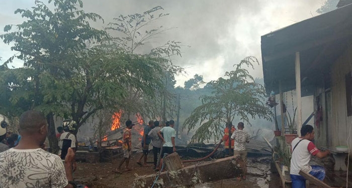 Warga bersama apparat kepolisian berusaha memadamkan api yang menghanguskan dua unit rumah di Abe Pantai,Kota Jayapura.