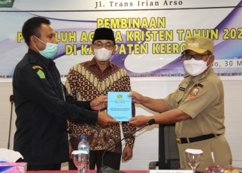 Caption : Kepala Kanwil Kemenag Provinsi Papua, Pendeta Amsal Yowei ketika memberikan plakat kepada Wakil Bupati Keerom, Drs. Wahfir Kosasih, SH, MH, MSi, saat kegiatan Pembinaan Penyuluh Agama Kristen di Kabupaten Keerom,Selasa (30/3)