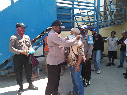 Ketika Kapolsek memberikan masker bagi penumpang, di Pelabuhan Jayapura.  
