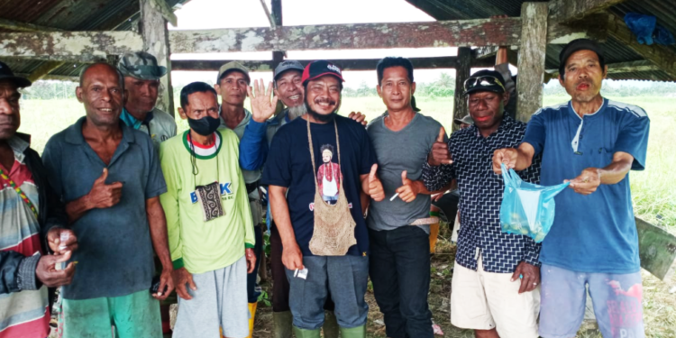Foto bersama Sekretaris Komisi B DPRD Kabupaten Jayapura, Rasino dan warga sekitar disela sela mengawasi pekerjaan pengerukan irigasi. Untuk membantu kebutuhan air mengalir kepersawahan, ia harus keluarkan uang pribadinya membayar alat berat. (FOTO SITIMEWA/RED)