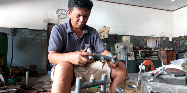 Mantan Wakil Bupati Jayapura, Giri Wijayantoro ketika sedang merakit pompa air dibengkel miliknya. Pompa air yang dirakitnya akan dipakai dilahan cabe miliknya di Distrik Nimbokrang. (Foto Hans Palen)