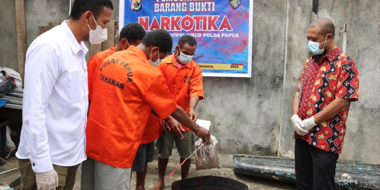 Empat tersangka saat memusnakan sendiri narkoba ganja seberarat 609,7 Gram di halaman Polda Papua.