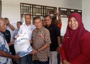 Wabup Biak Numfor, Calvin Mansnembra didampingi pimpinan Perum Bulog Kabupaten Biak Numfor, Sheika Irawati juga Kepala Distrik Biak Timur, Lukas Morin saat penyerahan bantuan pangan secara simbolis ke kepala kampung.(FOTO LISA R.)