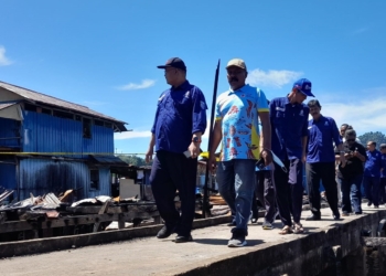 Foto : Andika.
Keterangan Foto : Pihak PTAMJ RN Perseroda bersama warga meninjau lokasi bekas kebakaran di Dok 8, Kelurahan Imbi, Jayapura Utara, Selasa (12/5/2026). Dalam kunjungan tersebut, PTAMJ RN turut menyalurkan bantuan air minum dalam kemasan serta menyiagakan satu unit tangki air bersih bagi warga terdampak.